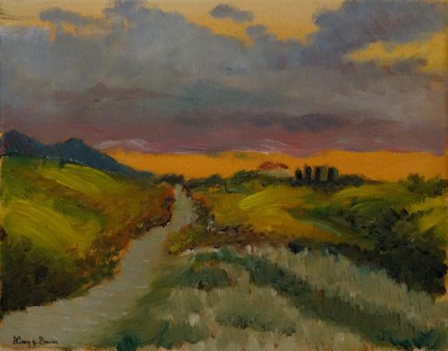 Toscana I Sehnsucht. Toskanische Landschaft mit Sonnenuntergang und violett gefärbter Wolke. Zwischen Hügeln führt ein Weg zum Horizont.