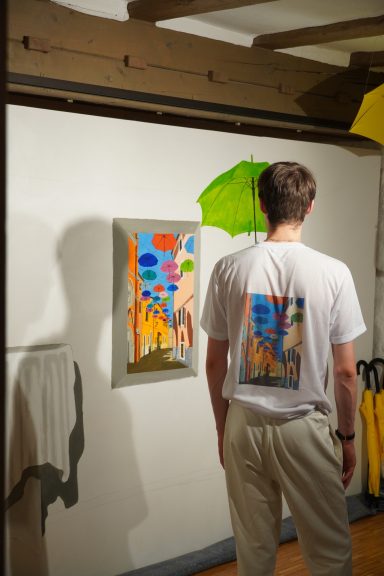 Ich betrachte mein Gemälde während der Entstehung. Auf meinem T-Shirt ist ein Ausschnitt des Gemäldes gedruckt.